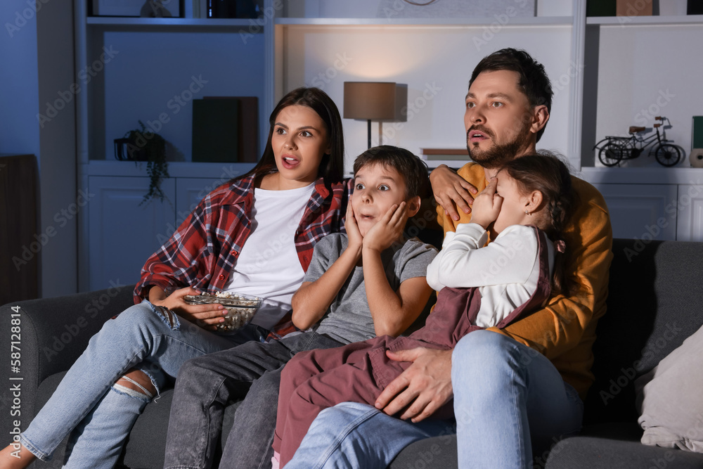 Emotional family watching TV at home in evening Emotional family watching TV at home in evening