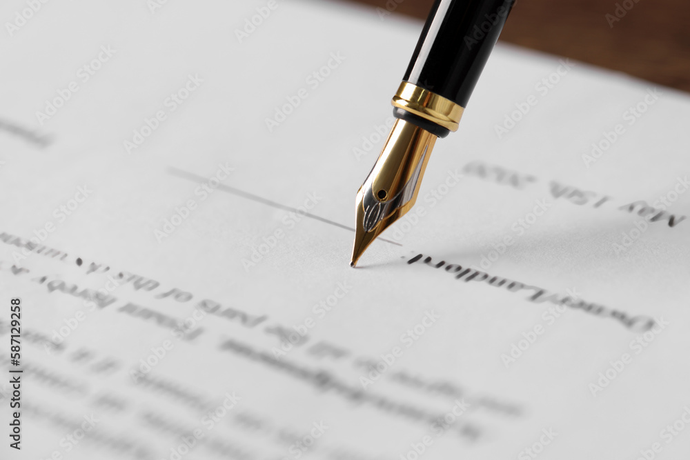 Writing on document with fountain pen at wooden table, closeup. Notary contract Writing on document with fountain pen at wooden table, closeup. Notary contract