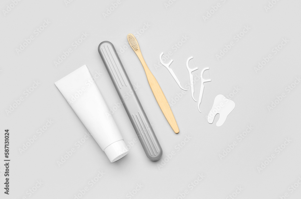 Floss toothpicks, tube of paste, brush and tooth model on grey background Floss toothpicks, tube of paste, brush and tooth model on grey background