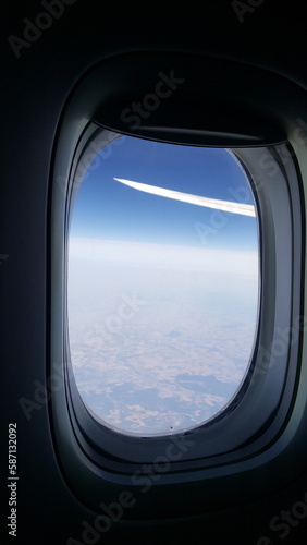 Janela de avião mostrando horizonte azul.