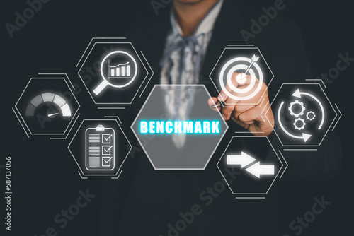 Business concept of benchmark, Business person hand holding pen and touching benchmark icon on virtual screen, Business, Technology, Internet and network.