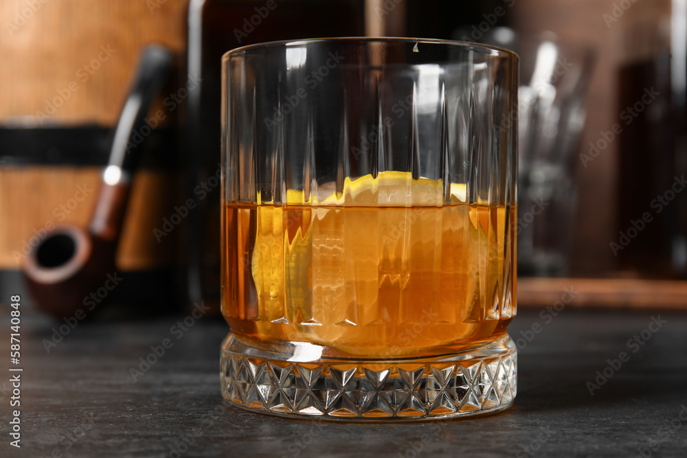 Glass of cold rum on dark background, closeup