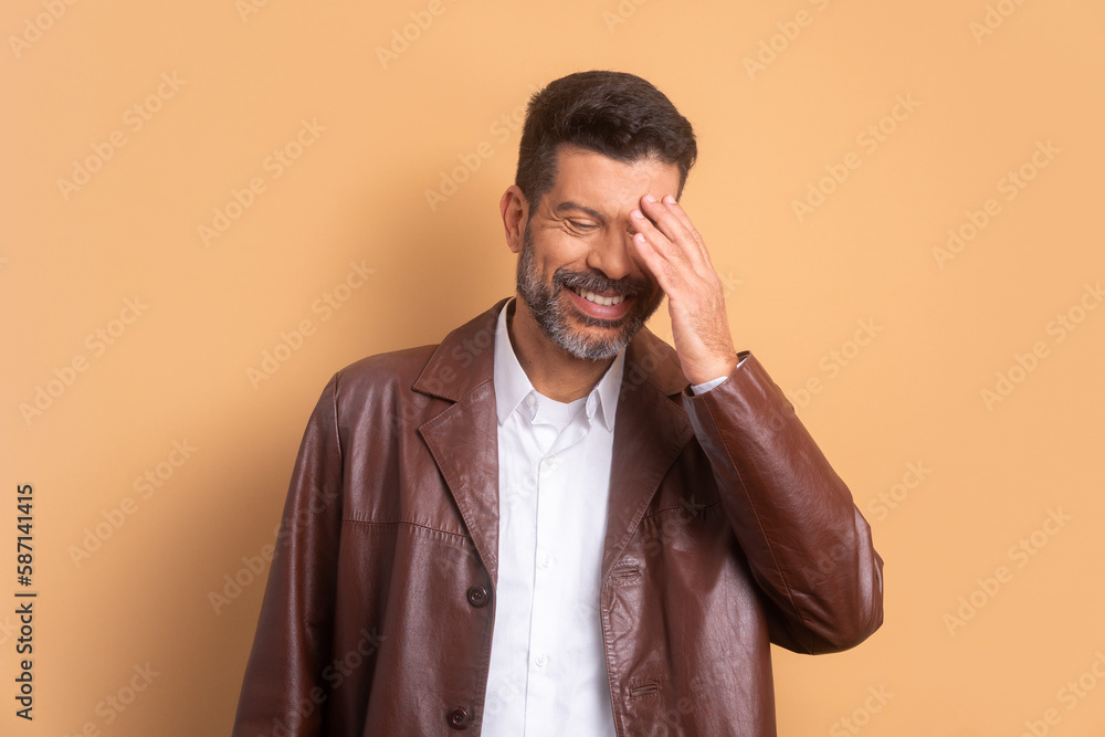 fun bearded man laughing happily in beige studio background. portrait, real people concept. fun bearded man laughing happily in beige studio background. portrait, real people concept.