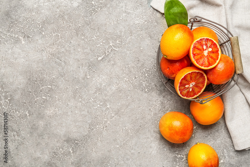 Metal basket with tasty blood oranges on grey background