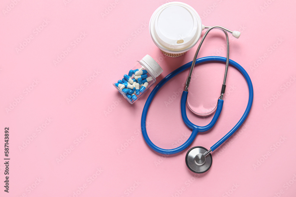 Fototapeta premium Stethoscope, coffee and pills on pink background