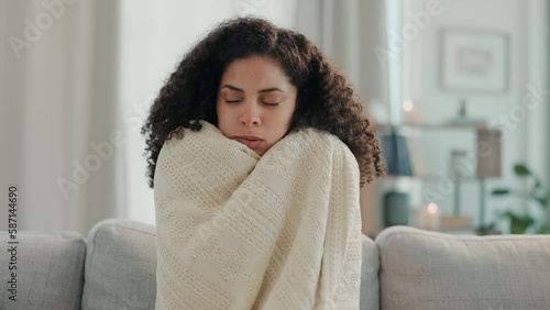 Cold, winter and woman with blanket on sofa for warmth, shivering virus and freezing weather. Sick girl, flu and freeze on couch with body hypothermia, medical illness and fever chills in living room photo