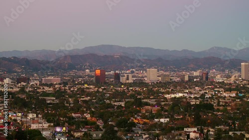Aerial Panning Shot Of Residential Houses By Hollywood Sign On Mountain Against Clear Sky At Dusk - Culver City, California