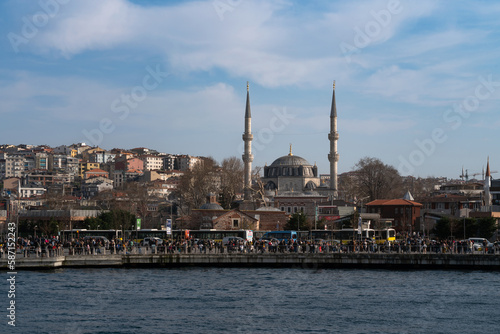 View of the embankment of the Uskudar district of Istanbul province and the Yeni Valide Mosque from the waters of the Bosphorus Strait on a sunny day, Istanbul, Turkey