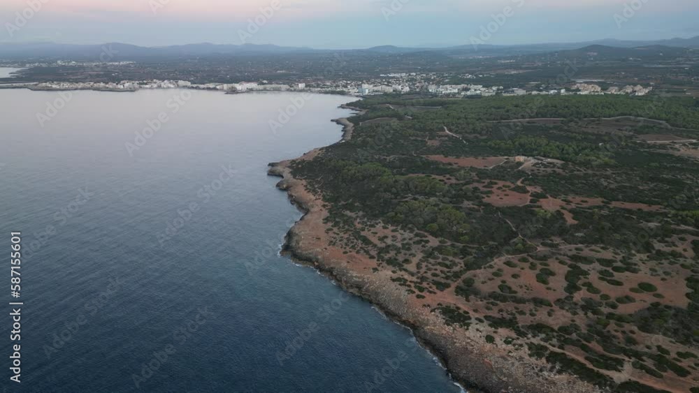 Panoramic Aerial View Of Pristine Rocky Beach With Cityscape At Background In Mallorca, Spain. Panoramic Aerial View Of Pristine Rocky Beach With Cityscape At Background In Mallorca, Spain.