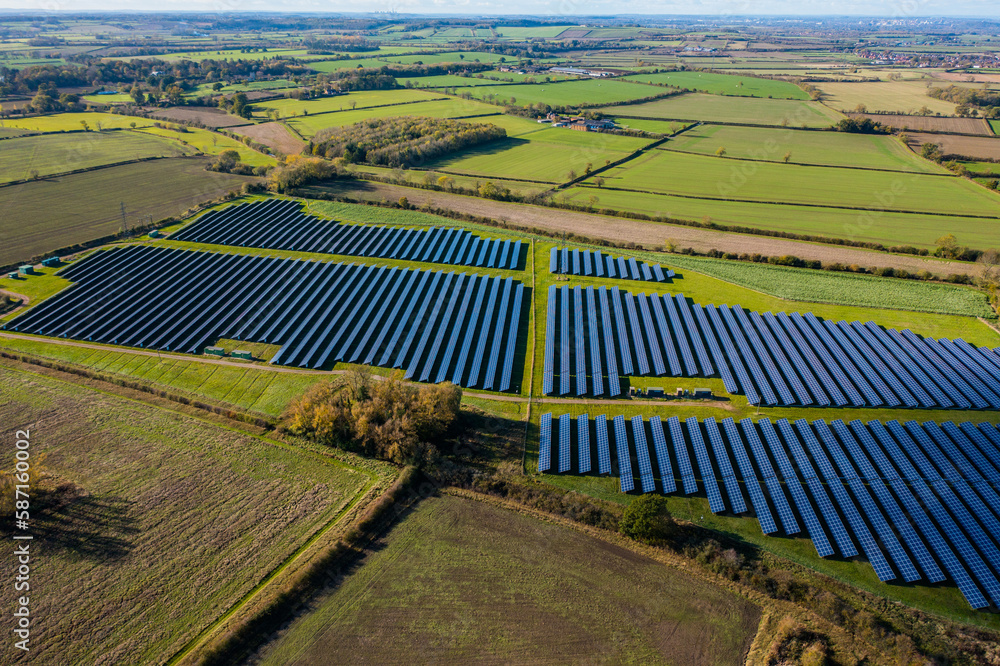 Power plant using renewable solar energy with sun. Aerial looking over a modern solar farm. English countryside panoramic. solar power station. 