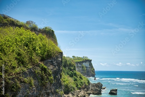 Fotografie Panoramic view over the coastline with its imposing cliffs overgrown with bushes from Suluban beach on Balin in Indonesia