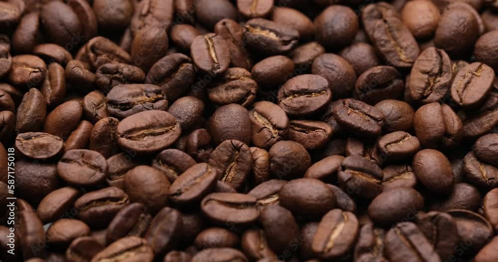 Roasted coffee beans spinning, top view - High quality 4k footage Roasted coffee beans spinning, top view - High quality 4k footage