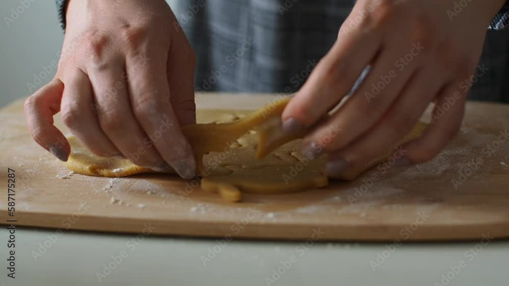 Womens hands close-up with ginger dough and carving figurines from it. The shapes of rabbit. Cutting sugar cookie dough with Easter shaped cookie cutters. Preparation for Easter. Holidays baking. Womens hands close-up with ginger dough and carving figurines from it. The shapes of rabbit. Cutting sugar cookie dough with Easter shaped cookie cutters. Preparation for Easter. Holidays baking.