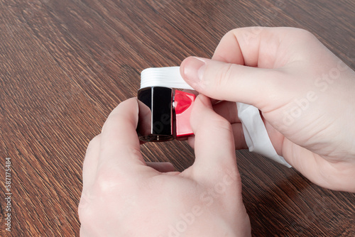 Man using teflon tape to seal water ball faucet with red valve. Wrap PTFE tape on valve thread. Brass water tap close up. Shining mini ball valve photo