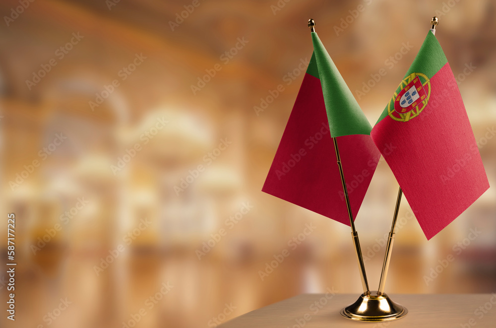 Small flags of the Portugal on an abstract blurry background