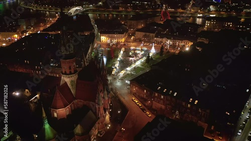 Drone view of Christmas stalls and carousel on the Podgorski Square with St. Joseph's Church in Krakow, Poland at night. photo