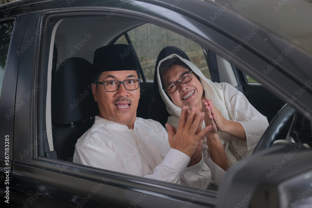 Adult moslem man and woman greeting from inside the car cabin