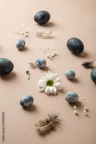 Stylish Easter composition with blue Easter eggs and flowers on a gentle background. Copy space, top view, flat lay. Easter concept
