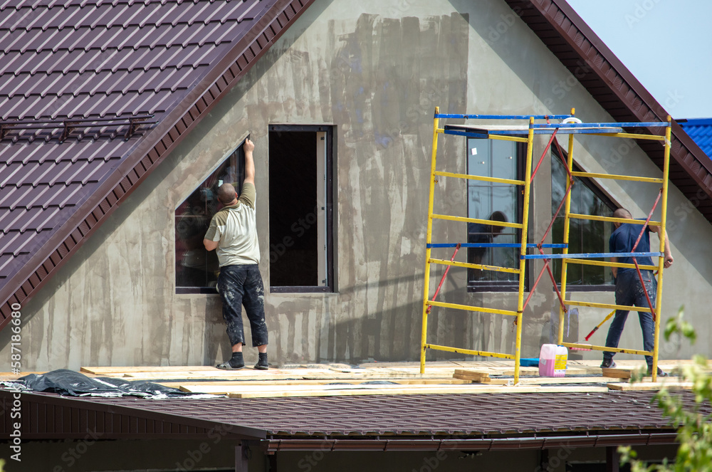 Workers are priming outside the walls of the house. Workers are priming outside the walls of the house.