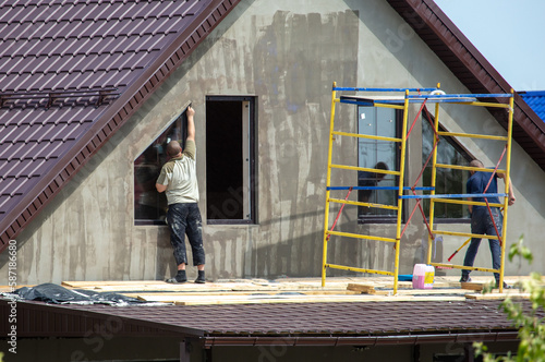 Workers are priming outside the walls of the house.