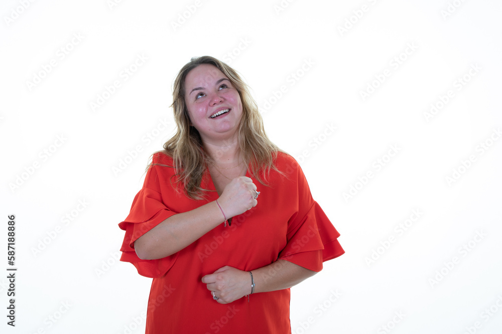 Happy young blond woman curvy hand on chest portrait laughing smiling looking up copy space on white background Happy young blond woman curvy hand on chest portrait laughing smiling looking up copy space on white background