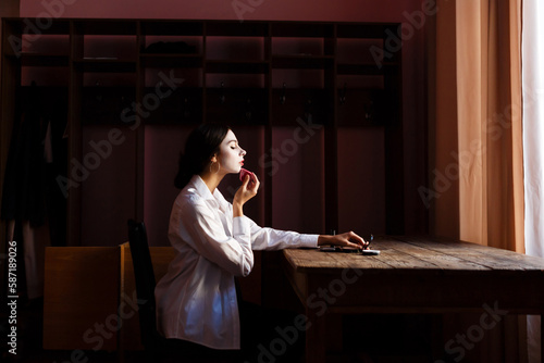 actress applies makeup to her face while sitting at rehearsal theater