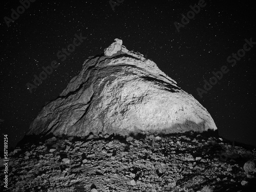 Illuminated rock formation at the Trona Pinnacles at night with stars.