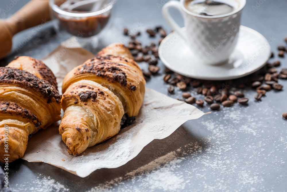 Delicious freshly baked croissants with chocolate and coffee on a dark background. French breakfast. Delicious pastries close-up. The context of a bakery with delicious bread. Confectionery products. Delicious freshly baked croissants with chocolate and coffee on a dark background. French breakfast. Delicious pastries close-up. The context of a bakery with delicious bread. Confectionery products.