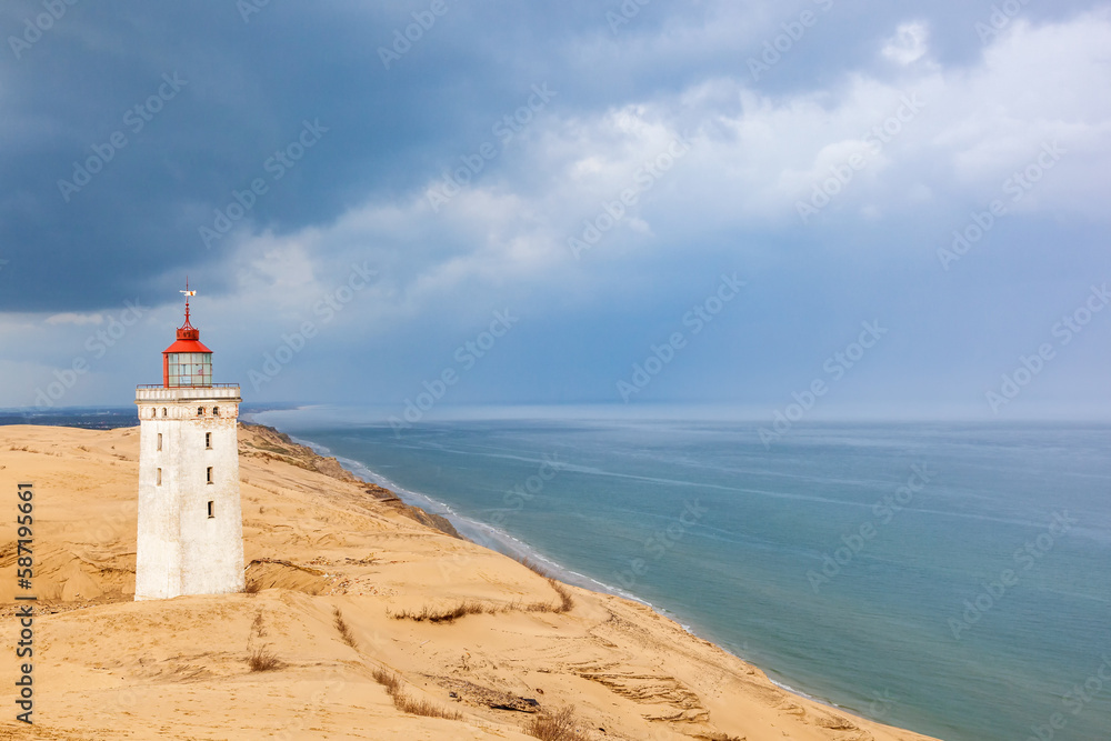 Seascape view at Rubjerg knude lighthouse with storm clouds
