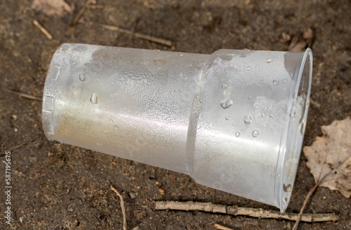 A glass from a plastic bottle on the ground.