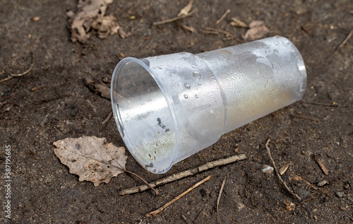 A glass from a plastic bottle on the ground.
