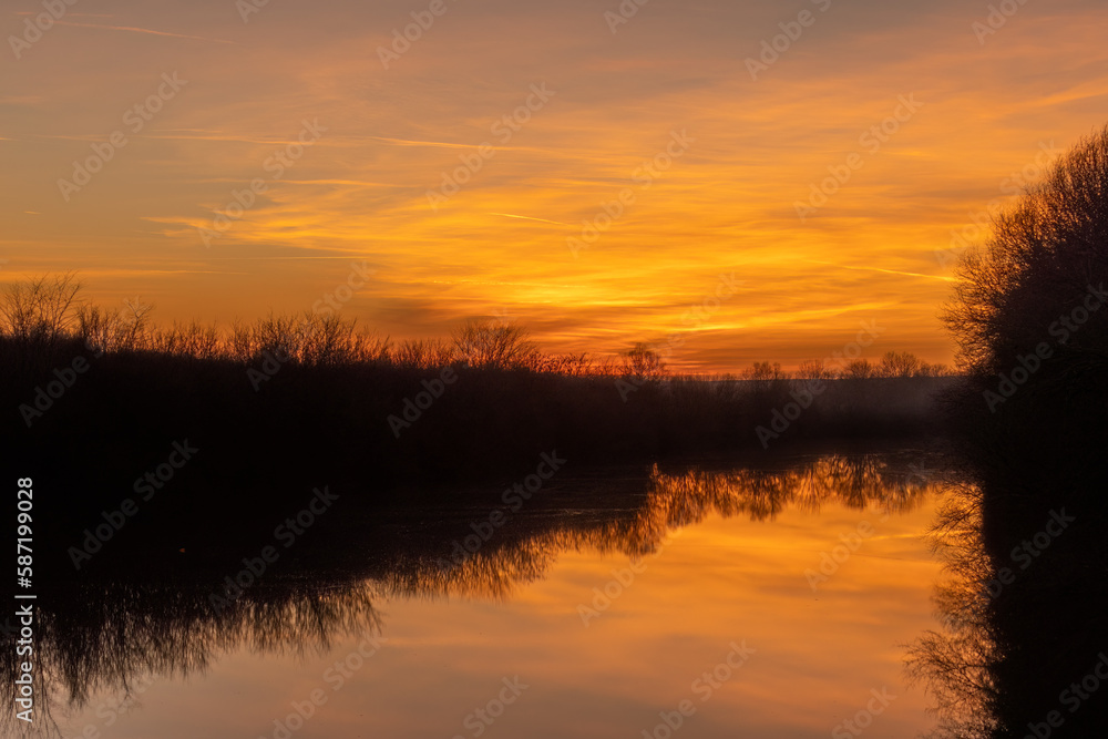 Fiery sunset over the river's water
