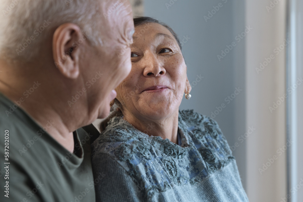 Happy senior couple at home next to the window Happy senior couple at home next to the window