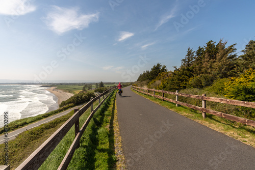 Cyclist woman riding touring bike on road over the sea coast photo