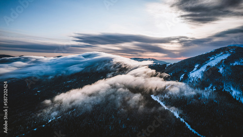 Low winter clouds blanket snow covered Saddleback Mountain, Maine