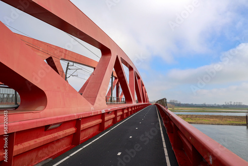 Red steel bridge called Hanzeboog over the river IJssel between Hattem and Zwolle photo