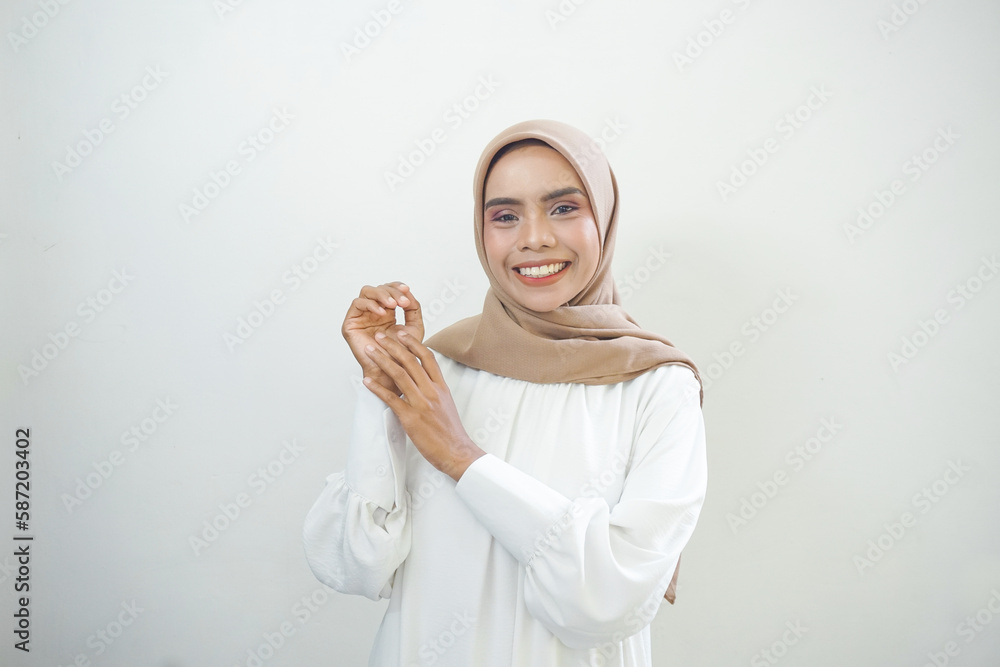 Smiling young Asian Muslim woman feels confident and joyful isolated over white background