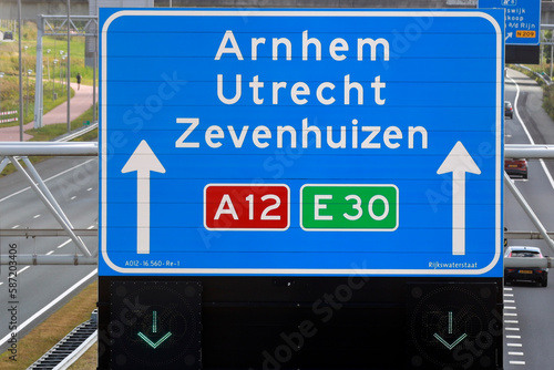 Blue signpost on the highway A12 direction to Arnhem, Utrecht and Zevenhuizen