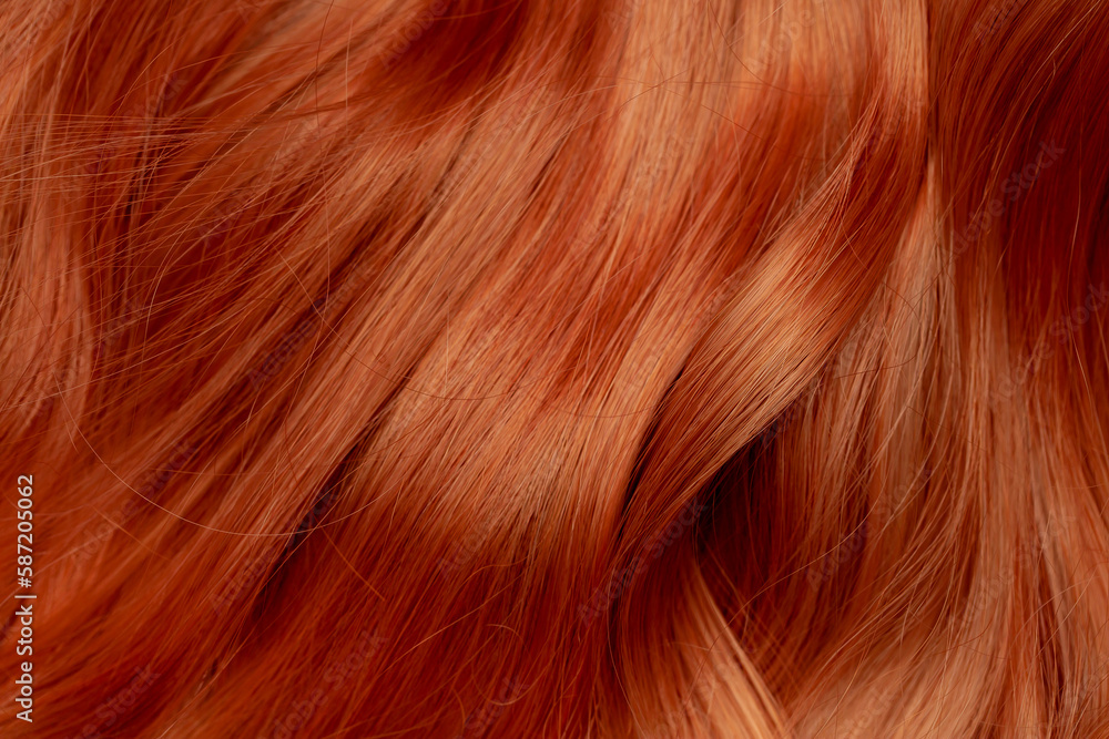 Fototapeta premium Red hair close-up as a background. Women's long orange hair. Beautifully styled wavy shiny curls. Hair coloring bright shades. Hairdressing procedures, extension.