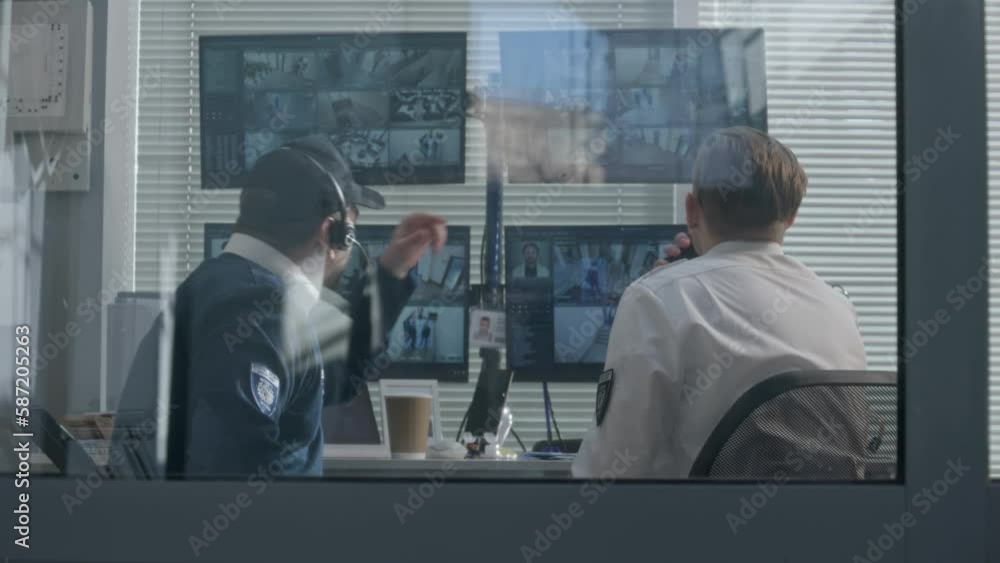 Vidéo Stock Security officers sit in surveillance room and monitor CCTV
