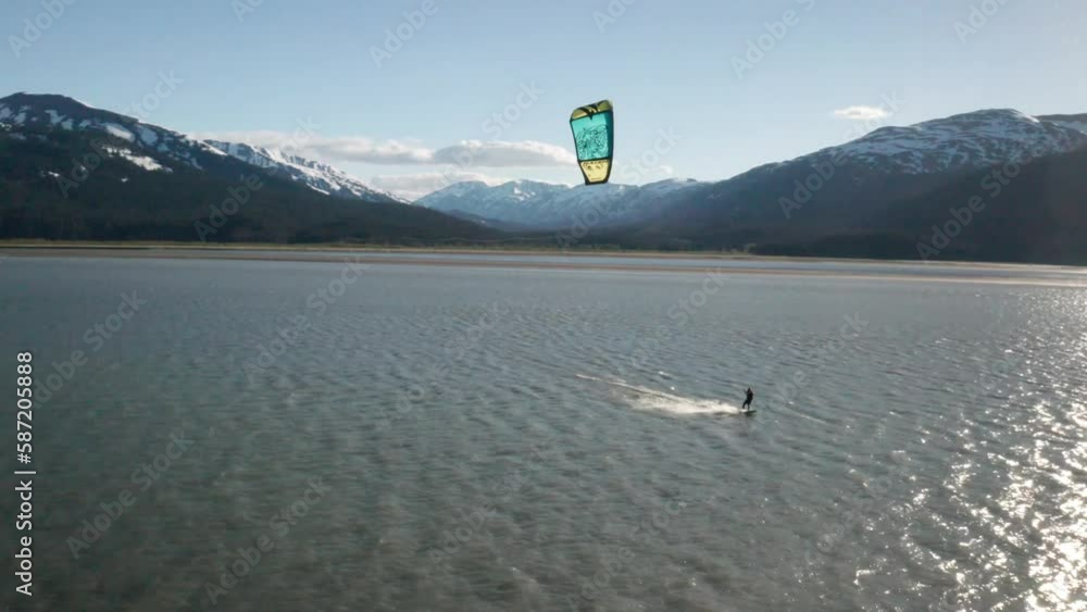 Drone footage of a water skier paraskiing with a parachute on a windy