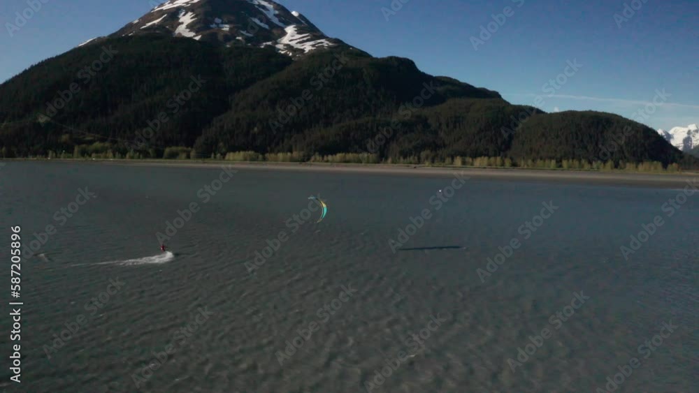 Drone footage of a water skier paraskiing with a parachute on a windy