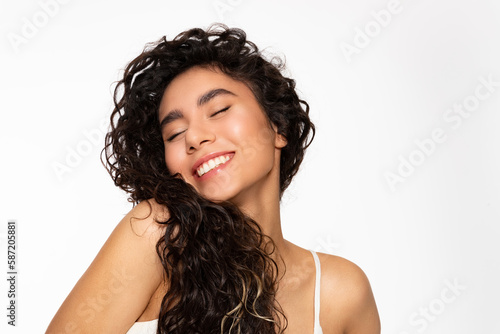 Happy beautiful young woman with black curly hair on white background photo