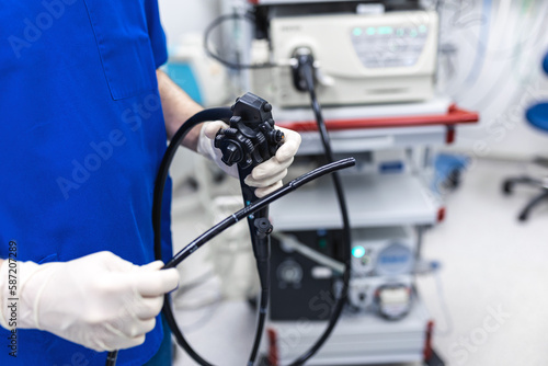 Doctor proctologist holding endoscope during colonoscopy. Probe colonoscope. Doctor gastroenterologist with probe to perform gastroscopy and colonoscopy photo