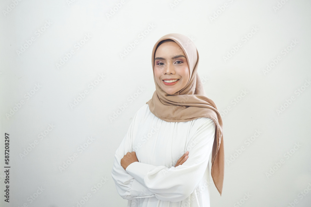 Smiling young Asian Muslim woman feels confident and joyful isolated over white background Smiling young Asian Muslim woman feels confident and joyful isolated over white background