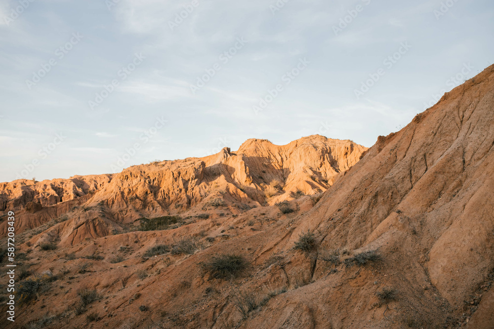 The photo showcases a panoramic view of sandy canyons during a sunset.