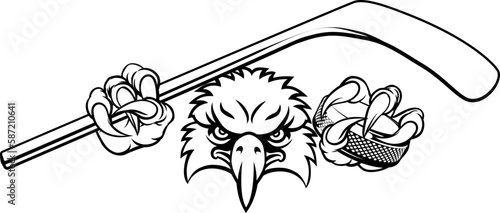 An eagle ice hockey player animal sports mascot holding a hockey stick and puck photo