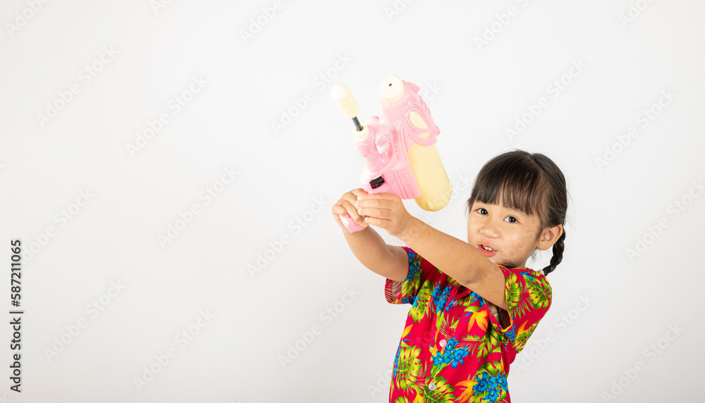 Happy Songkran Day, Asian kid girl with floral shirt hold water gun, Thai child funny hold toy water pistol and smile, isolated on white background, Thailand Songkran festival national culture concept Happy Songkran Day, Asian kid girl with floral shirt hold water gun, Thai child funny hold toy water pistol and smile, isolated on white background, Thailand Songkran festival national culture concept