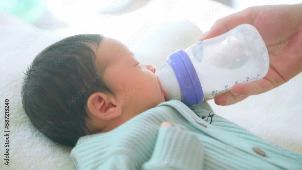 Loving mother feeding her little girl child with breast milk baby