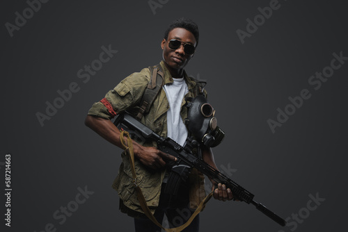Studio shot of somali pirate man dressed in uniform posing agianst gray background.